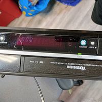 Front display lit showing unit powers up, model branding visible