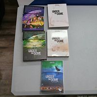 Front view of all five Under The Dome DVD cases showing cover art and confirming disc presence