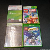 Front view of four Xbox game cases and sleeves showing titles and condition