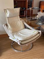 Front view of white leather recliner showing cushions, frame, and chrome base