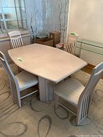 Dining table with four chairs arranged around it