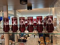 Full set of eight ruby red cut-to-clear tumblers on shelf