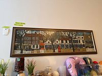 Full view of framed panoramic print on wall above shelf