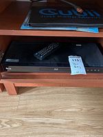 Front view of LG BD620C player on shelf with remote placed on top