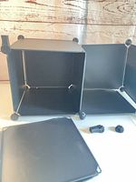 Two assembled black plastic storage cubes with corner connectors visible