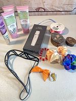 Group view of hand creams, epilator box, hair accessories, ribbon spool, wood boxes