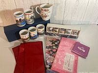 Group shot of cups, creamer, fabrics, coaster stack and box