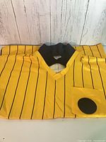 Jersey laid flat showing front, pinstripes, pocket with round patch