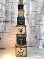 Full stack of seven nesting boxes showing size gradient and motifs