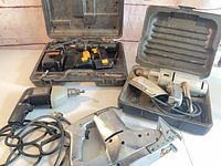 Group view of four power tools with cases and cords