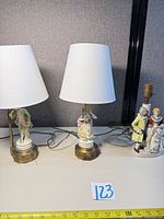 Three porcelain figurine table lamps, two with shades, one without