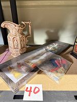 Overall lot view showing pitcher, framed plaques, items bagged