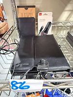 Lot overview on shelf showing folio, phone case box, passport holder, clip accessory