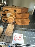 Stack of three wooden hand screw clamps on shelf