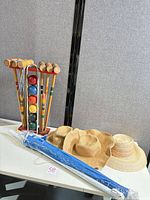 All items together: croquet set on stand, umbrella in packaging, three straw hats