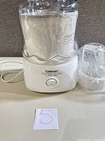 Overall view showing base unit, freezer bowl wrapped in plastic and lid