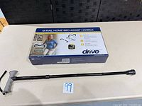 Boxed M-Rail bed assist handle and adjustable cane on table