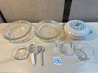 Full lot: five glass bowls, enamel skillet with lid, strainer, spoon