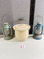 group view of chamber pot with lid flanked by two lanterns