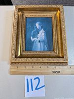 Full view of framed portrait with ruler for scale