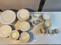 Stacks of plates, bowls, cups, gravy boat, creamer on table