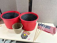 overview of two red planters, tan planter, drainage covers pack, five flags