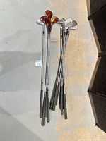 Full view of all clubs grouped on floor, showing quantity and mix of woods and irons