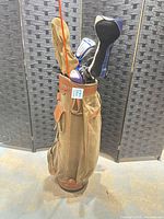 Full view of canvas/leather golf bag containing assorted clubs