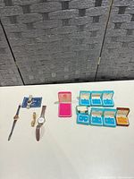 Overview of four watches, pink pendant box, multiple earring boxes