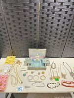 Overview of lot showing music box, raw findings trays, assorted jewelry