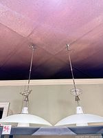 Both pendant lights showing frosted glass shades and rods