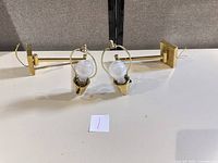 Both polished brass wall sconces front view with bulbs