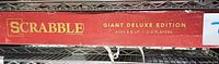 Side panel of Scrabble Giant Deluxe Edition box with wear and scuffs visible