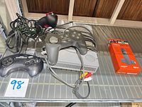 Sony PS1 console, controllers, Fire TV Stick 4K box, AV cable displayed on shelf