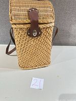 Front view of wicker picnic basket with leather latch and straps