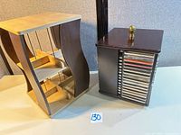 two wood CD storage units side by side, tower on left, carousel on right with CDs visible