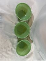 Top view of three green Fire-King swirl bowls