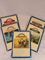 All five booklets fanned out showing covers and quantity