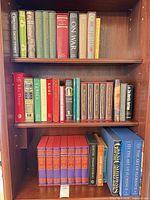 Full view three shelves loaded with books and slipcased sets