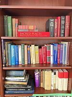 Full view of three shelves filled with assorted hardcover books