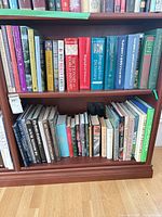 Two shelves filled with assorted hardcover and paperback books