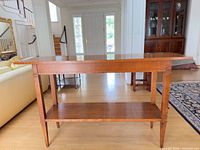 Front view of wooden console table showing full length and lower shelf