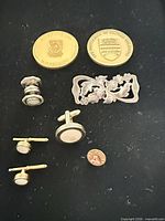 Group view showing all items: cufflinks, studs, brooch, pins, university coins
