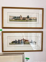 Two framed landscape prints on wall