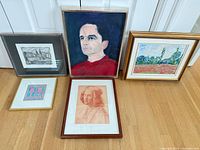 Group shot displaying all five framed artworks upright on floor
