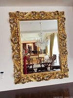 full view of gilt framed mirror mounted on wall
