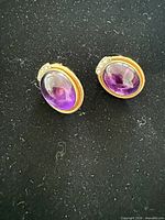 Front view showing amethyst cabochons, gold bezels, diamond accents