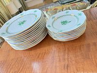 Stack of dinner and bread plates showing pattern and gold rims