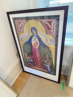 Full view of framed Christian icon print standing against wall