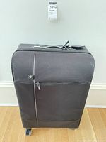 Front view of black BMW rolling suitcase showing logo, telescopic handle housing and wheels